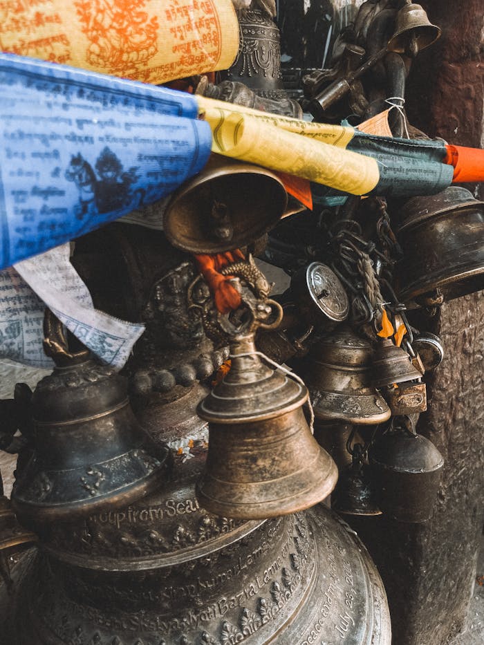 Close-up of Buddhist prayer flags and bells in Kathmandu, Nepal, symbolizing spirituality and meditation.